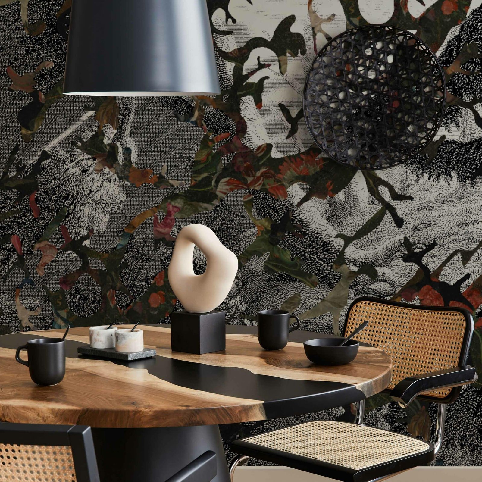 Interior design of modern dining room space with stylish chairs, wooden table, black pedant lamp, decoration, ceramic vessel, teapot with cups. Fancy home decor. Template.